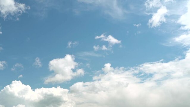  Clouds. Light white clouds fly across a bright blue sky with grey sky in the middle. Spring cloudscape background. Timelapse of clouds