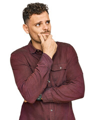 Young hispanic man wearing casual clothes thinking worried about a question, concerned and nervous with hand on chin