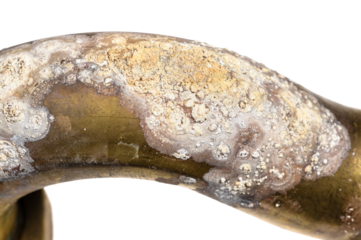 salt deposits on brass drain pipe close up isolated on white background