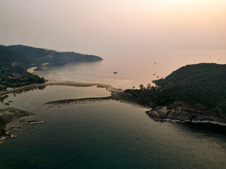 Aerial drone view small Koh Ma island, Ko Phangan Thailand. Exotic coast panoramic landscape, Mae Haad beach, summer day. Sandy path between corals. Vivid seascape, mountain coconut palms from above.