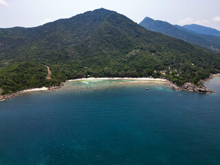 Aerial drone view small Koh Ma island, Ko Phangan Thailand. Exotic coast panoramic landscape, Mae Haad beach, summer day. Sandy path between corals. Vivid seascape, mountain coconut palms from above.