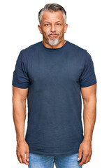 Fototapeta premium Middle age grey-haired man wearing casual clothes puffing cheeks with funny face. mouth inflated with air, crazy expression.