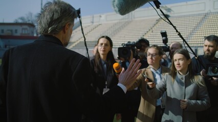 Interview of private investor at press conference near soccer field for TV news. SEO or director of...