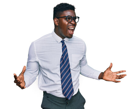 Handsome business black man wearing white shirt and tie crazy and mad shouting and yelling with aggressive expression and arms raised. frustration concept.