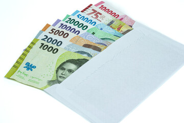 Indonesian currency. Stack of Rupiah or IDR banknotes inside white envelope on white background