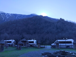 Horizontal mountain landscape with an apiary in Abkhazia. Sunrise from behind the mountain.