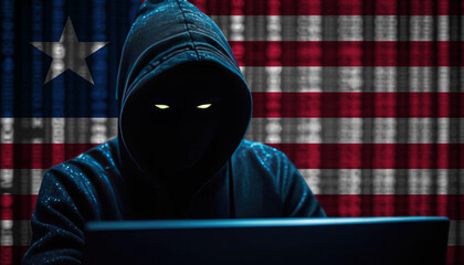Hacker in a dark hoodie sitting in front of a monitors with Liberia flag and background cyber security concept