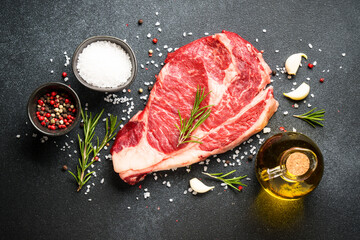 Beef steak, raw meat on black.