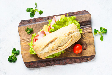 Ciabatta sandwich with lettuce, cheese, tomatoes and ham. Fast food, snack or lunch.
