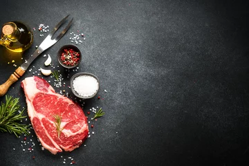  Raw meat steak with spices on black background. Beef steak ribeye. Top view with copy space. © nadianb