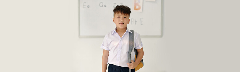 Header with smiling Vietnamese schoolboy standing at whiteboard