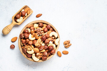 Nuts assortment at white background. Almond, hazelnut, cashew in wooden bowl.