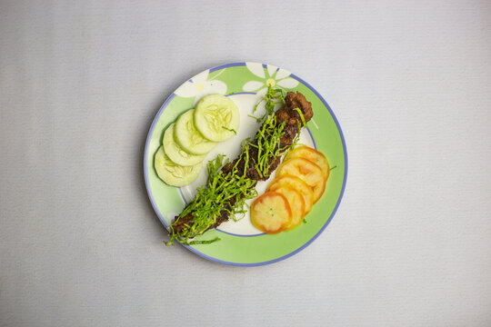 Beed Seekh kabab with tomato and cucumber served in plate isolated on background top view of bangladeshi, indian and pakistani traditional spicy food