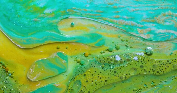 Video of greenish and yellow paint with moving bubbles creating a fluid continuum