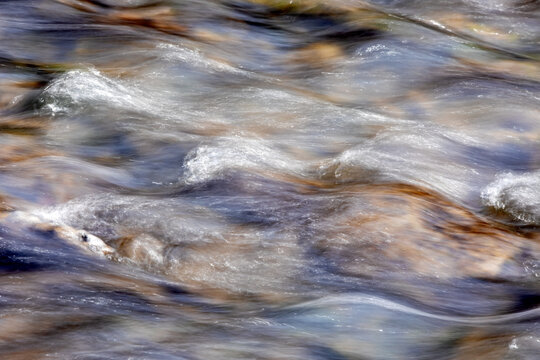 Abstract waterscape of flowing water in a stream, long exposure photography. 