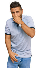 Fototapeta premium Handsome man with beard wearing casual clothes smelling something stinky and disgusting, intolerable smell, holding breath with fingers on nose. bad smell