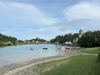 boats on the beach with old church tower in background
