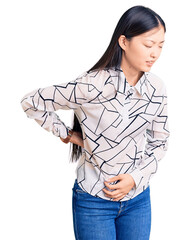 Young beautiful chinese woman wearing casual shirt suffering of backache, touching back with hand, muscular pain