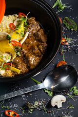Traditional tajine dishes, couscous and fresh salad on rustic wooden table. Tagine lamb meat and pumpkin. Top view. Flat lay