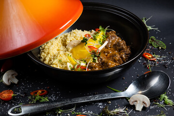 Traditional tajine dishes, couscous and fresh salad on rustic wooden table. Tagine lamb meat and pumpkin. Top view. Flat lay