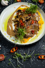 Tender veal with mushrooms is served in deep dish, filled with thick fragrant gravy. Tender meat is garnished with stewed vegetables and herbs.