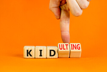 Kid or kidulting symbol. Concept words Kid or Kidulting on wooden cubes. Beautiful orange table...