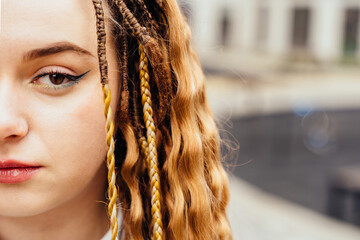 Half-face portrait of a full-figured girl with dreadlocks or African braids. Hair, freedom concept.