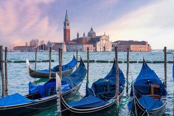 Basilica of San Giorgio Maggiore at sunset. In the foreground, gondolas are moored at square Piazza San Marco. - obrazy, fototapety, plakaty