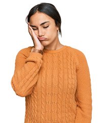 Young brunette woman wearing casual winter sweater thinking looking tired and bored with depression...