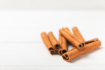 Cinnamon sticks on a textured wooden background. Cinnamon roll. Spicy spice for baking, desserts and drinks. Fragrant ground cinnamon. cinnamon powder Close-up. Place for text. copy space