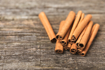 Cinnamon sticks on a textured wooden background. Cinnamon roll. Spicy spice for baking, desserts and drinks. Fragrant ground cinnamon. cinnamon powder Close-up. Place for text. copy space