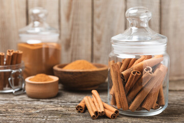 Cinnamon sticks on a textured wooden background. Cinnamon roll. Spicy spice for baking, desserts and drinks. Fragrant ground cinnamon. cinnamon powder Close-up. Place for text. copy space