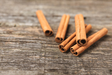 Cinnamon sticks on a textured wooden background. Cinnamon roll. Spicy spice for baking, desserts and drinks. Fragrant ground cinnamon. cinnamon powder Close-up. Place for text. copy space