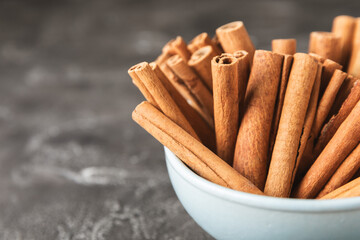Cinnamon sticks on a textured wooden background. Cinnamon roll. Spicy spice for baking, desserts and drinks. Fragrant ground cinnamon. cinnamon powder Close-up. Place for text. copy space