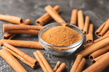Cinnamon sticks on a textured wooden background. Cinnamon roll. Spicy spice for baking, desserts and drinks. Fragrant ground cinnamon. cinnamon powder Close-up. Place for text. copy space