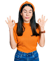 Young hispanic woman wearing casual clothes relaxed and smiling with eyes closed doing meditation gesture with fingers. yoga concept.