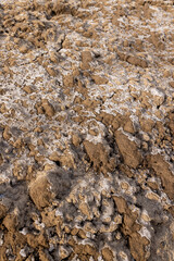 plowed frozen ground in the winter season with cracks