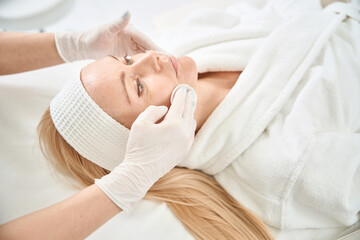Obraz na płótnie Canvas Young woman attending care procedure with cosmeceuticals