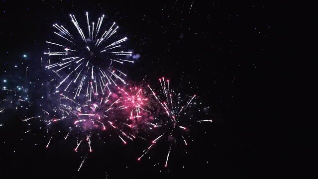 Colourful fireworks are glowing in the night sky. Happy new year concept.