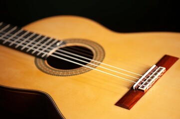 Obraz premium Classical Spanish flamenco guitar close up, dramatically lit isolated on black background with copy space.