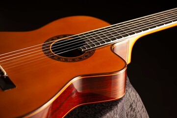 Classical Spanish flamenco guitar close up, dramatically lit isolated on black background with copy...