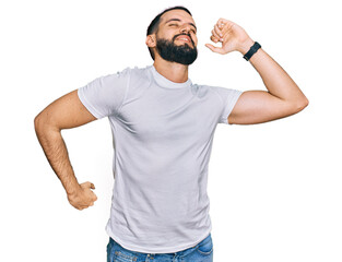 Young man with beard wearing casual white t shirt stretching back, tired and relaxed, sleepy and yawning for early morning