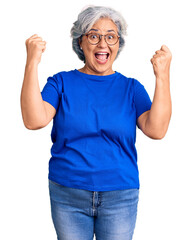 Senior woman with gray hair wearing casual clothes and glasses screaming proud, celebrating victory...