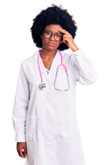 Young african american woman wearing doctor coat and stethoscope worried and stressed about a problem with hand on forehead, nervous and anxious for crisis