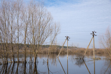 The flood of the river in the spring. The poles with electric poles are flooded. The flood.