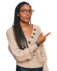 African american woman wearing casual clothes pointing with hand finger to the side showing...