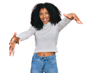 Young african american girl wearing casual clothes looking at the camera smiling with open arms for hug. cheerful expression embracing happiness.