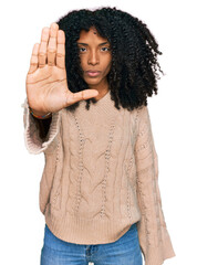 Young african american girl wearing casual clothes doing stop sing with palm of the hand. warning...