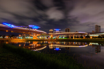 Fototapeta premium Amazing night scenery and reflections in an early summer evening near the Sanchong Station of Taoyuan Airport MRT in the New Taipei City Metropolitan Park.