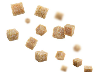 Brown cane sugar cubes falling on white background